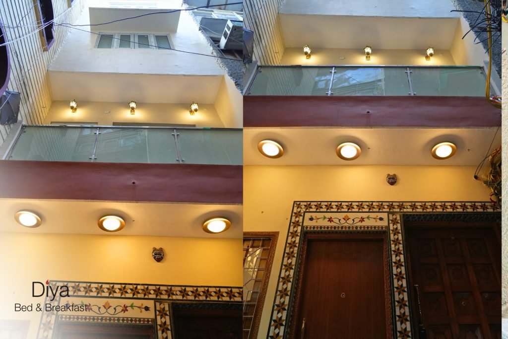 Exterior view of Diya Bed & Breakfast showing the building façade with balcony lighting, decorative entrance tiles, and wooden doors.